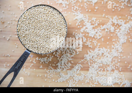 Fresh uncooked quinoa in measuring cup from above. Stock Photo