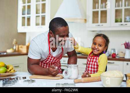 Cute little girl cooking pastry with her father Stock Photo