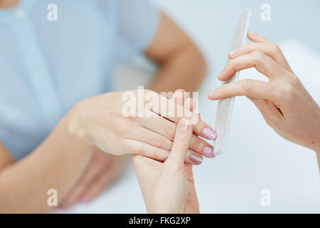 Close-up of a woman in a nail salon receiving manicure by a beautician at nail salon Stock Photo