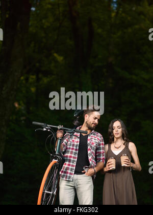 Beautiful young woman with two takeaway coffee cups standing in front ...