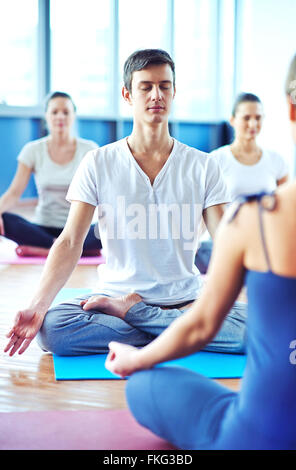 Young man meditating in yoga class Stock Photo