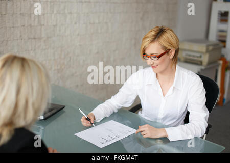 Blonde businesswoman fill out a form in office Stock Photo