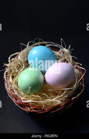 Easter eggs in nest on black background Stock Photo