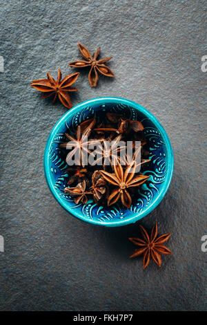 Authentic Blue Bowl Full of Anise Stars. Spice Background. Top View. Stock Photo