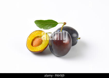 two and half ripe plums on white background Stock Photo