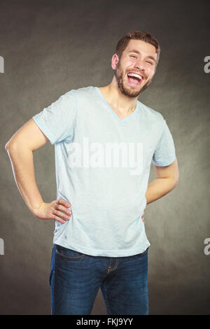 Portrait of happy handsome man in shirt laughing. Young content positive guy in studio on black. Stock Photo