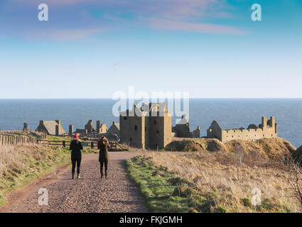 Two walkers approach historic Dunnottar castle near  Stonehaven in Aberdeenshire, Scotland, UK Stock Photo