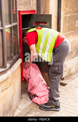 A postman empties the postbox at the post office in Chipping Campden , Gloucestershire , England , Britain , Uk Stock Photo