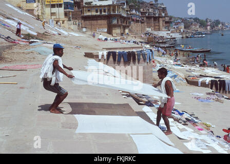 Wash day.Putting out washing,laundry to dry on ghats on banks of sacred Ganges River after washing in polluted waters,Varanasi. Stock Photo