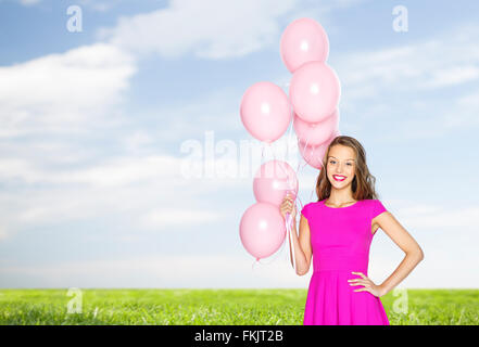 happy young woman or teen with helium air balloons Stock Photo