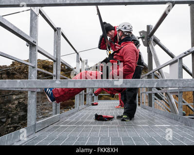 Man having safety checks on platform at start of zip wire ride at ZipWorld Titan in Snowdonia. Blaenau Ffestiniog North Wales UK Stock Photo