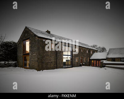 An exterior view of Cat Hill Barn, in Derbyshire, a modern barn conversion, in the winter covered in snow. Stock Photo