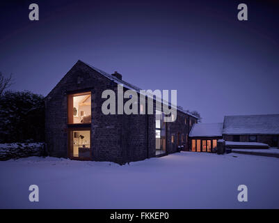 An exterior view of Cat Hill Barn, in Derbyshire, a modern barn conversion, in the winter covered in snow. Stock Photo