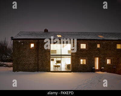 An exterior view of Cat Hill Barn, in Derbyshire, a modern barn conversion, in the winter covered in snow. Stock Photo
