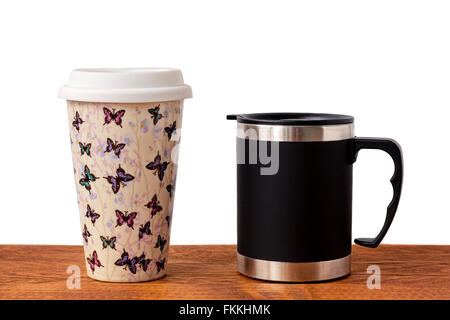 Two insulated coffee mugs on a wooden table. Stock Photo