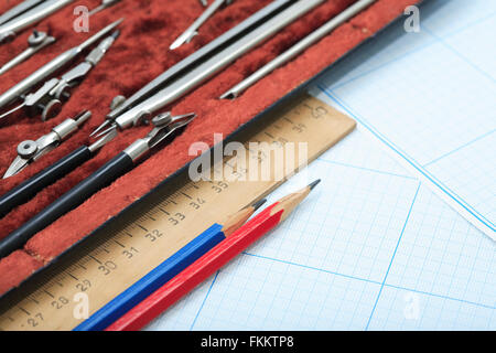 Set of drawing instrument in box and rulers on graph paper Stock Photo ...