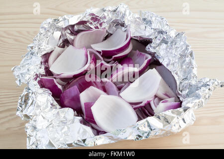 Fresh peeled and chopped red onion slices in tin foil Stock Photo