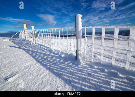 A frozen wire fence below the summit of Geal-charn Mor, Cairngorms in the Scottish Highlands, UK. Stock Photo