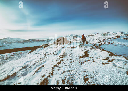 Hiking over snow covered mountains in the UK. Grain and colour styling applied Stock Photo