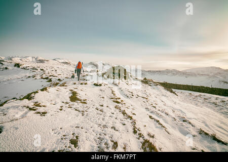 Hiking over snow covered mountains in the UK. Grain and colour styling applied Stock Photo