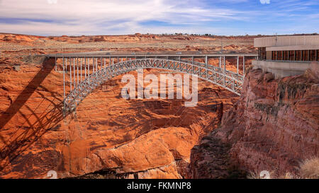 A steel arch bridge spans the canyon next to the Glen Canyon Dam visitor center in Page, Arizona Stock Photo