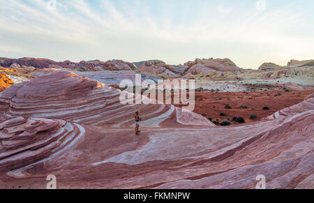 Tourist in the Fire Wave rock formation, Valley of Fire State Park, Nevada, USA Stock Photo