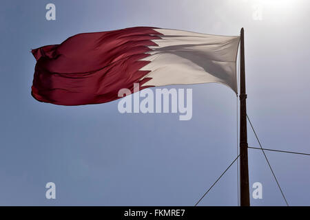 Qatar flag against a blue sky waving in the wind, Doha, Qatar Stock Photo