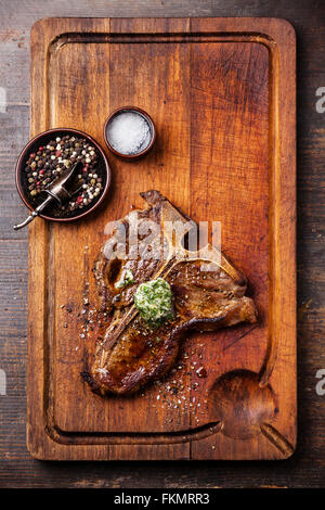 Grilled T-Bone Steak and herb butter on wooden cutting board Stock Photo