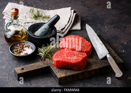 Raw fresh marbled meat Steaks with seasonings on dark background Stock Photo