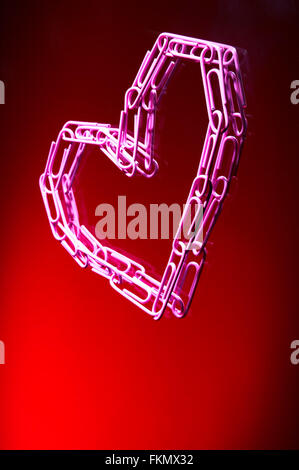 Heart from paper clips on a red background Stock Photo