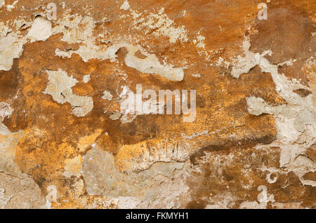 Detail of an old ocher wall with crumbling plaster Stock Photo