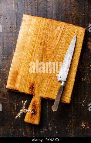 Chopping board and kitchen knife on dark wooden background Stock Photo