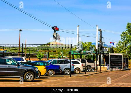 People enjoying the thrill of a zip-line set high above a car park Stock Photo