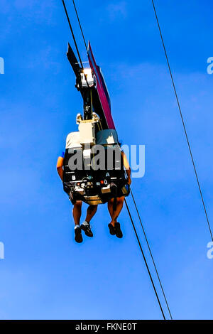 People enjoying the thrill of a zip-line amusement ride Stock Photo