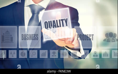 Businessman pressing a Quality concept button. Stock Photo