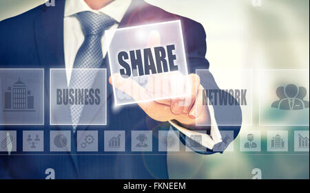 Businessman pressing an Sharing concept button. Stock Photo