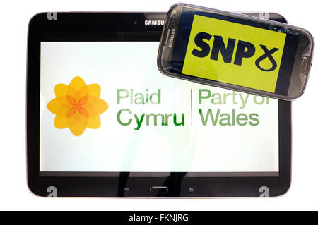 The Plaid Cymru and SNP logos displayed on the screens of a tablet and a smartphone against a white background. Stock Photo