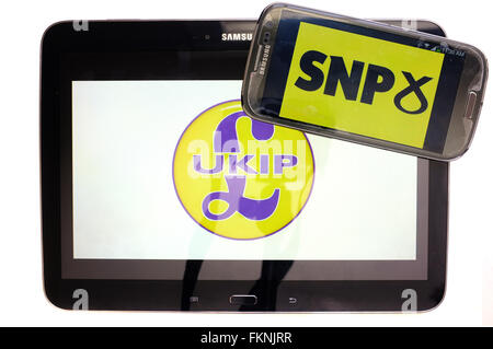 The UKIP and SNP logos displayed on the screens of a tablet and a smartphone against a white background. Stock Photo