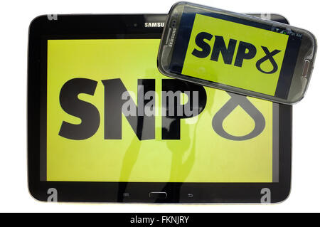 The SNP logo displayed on the screens of a tablet and a smartphone against a white background. Stock Photo