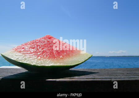 Sliced ripe watermelon in the top of the wooden and isolated on sky background. Selected focus for DOF Stock Photo