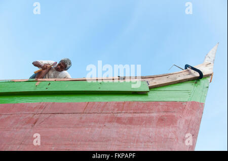 Local boat maker repairing the wooden boat in Mabul Island, Malaysia. Stock Photo