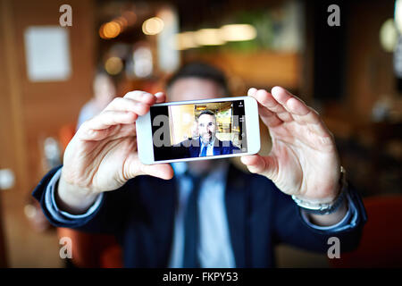 Smiling businessman taking selfie with his cellphone Stock Photo