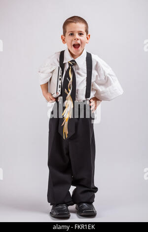 Portrait of a boy wearing oversized clothes and holding a file