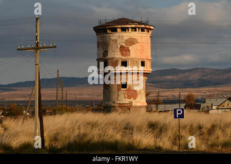 Trans Siberian Railway in Siberia - old water tower next to railway line with storm clouds in background Stock Photo