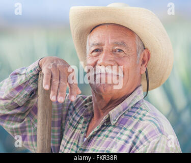 Older Hispanic farmer smiling in field Stock Photo