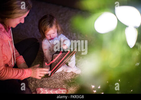 Caucasian mother and daughter opening Christmas gift Stock Photo