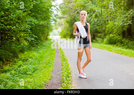 Woman runner rests after workout outdoor Stock Photo