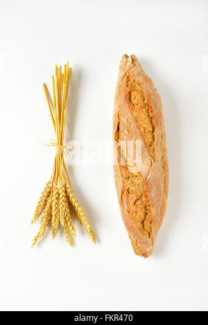 freshly baked french baguette and bunch of ripe ears on white background Stock Photo