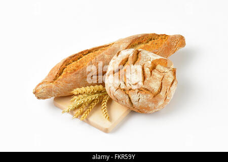 freshly baked bread and baguette on wooden cutting board Stock Photo