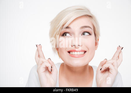 Closeup portrait of a smiling woman with fingers crossed gesture isolated on a white background Stock Photo